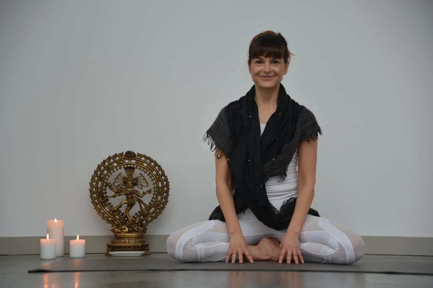 Person in Siddhasana-Pose in der warmen Shala